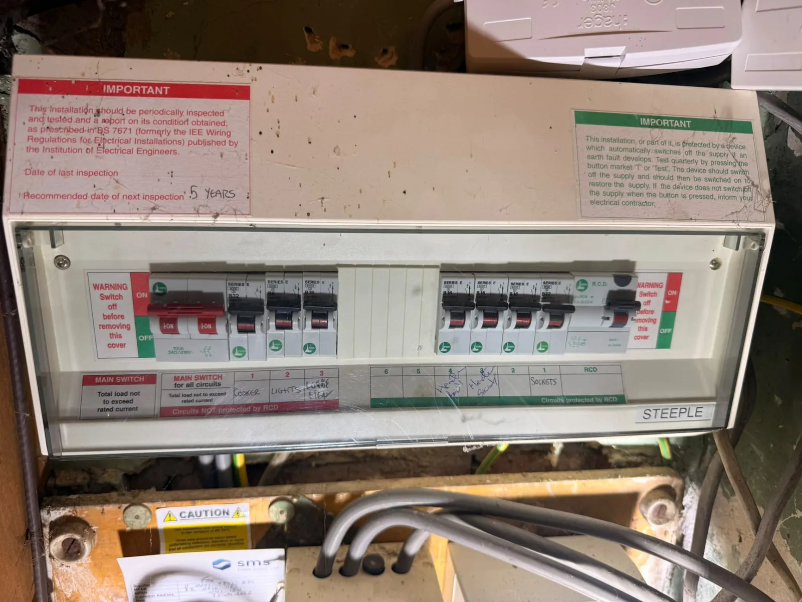 Outdated consumer unit with exposed wiring, the kind of installation Doe Electrical puts right