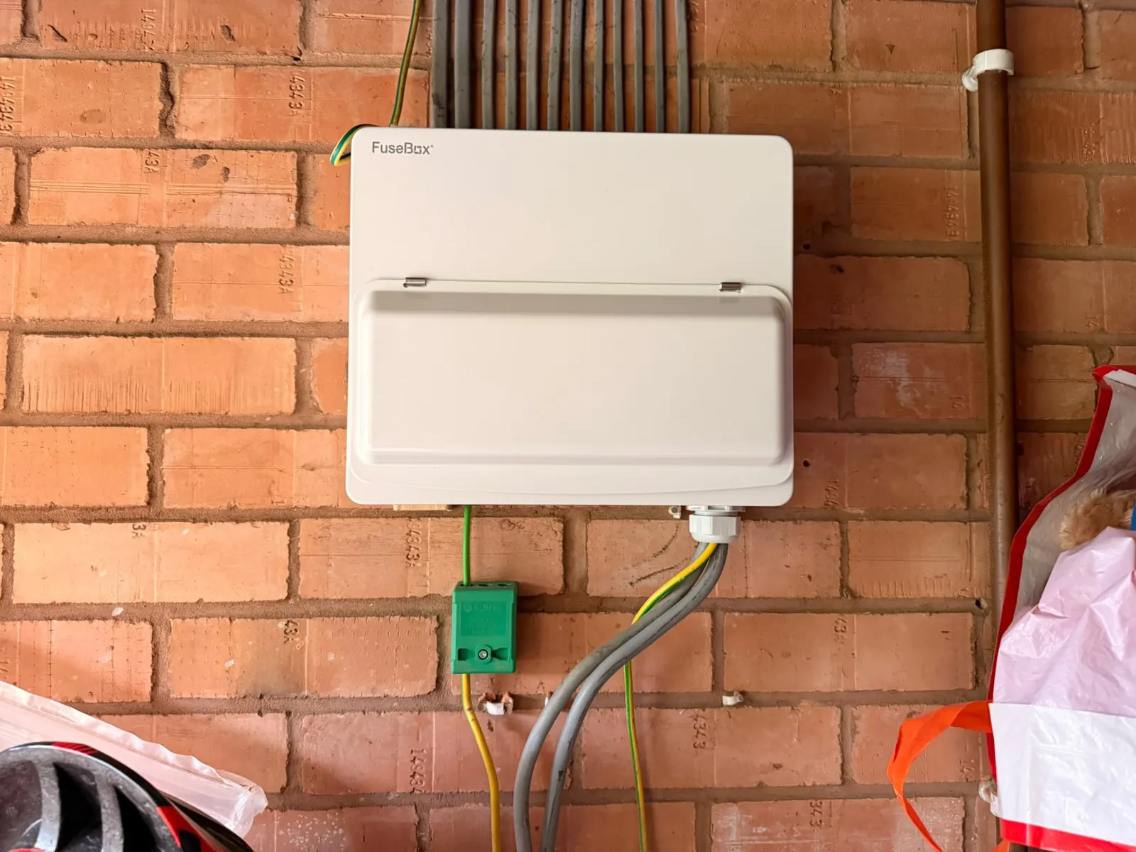New consumer unit mounted on brickwork with earth bonding