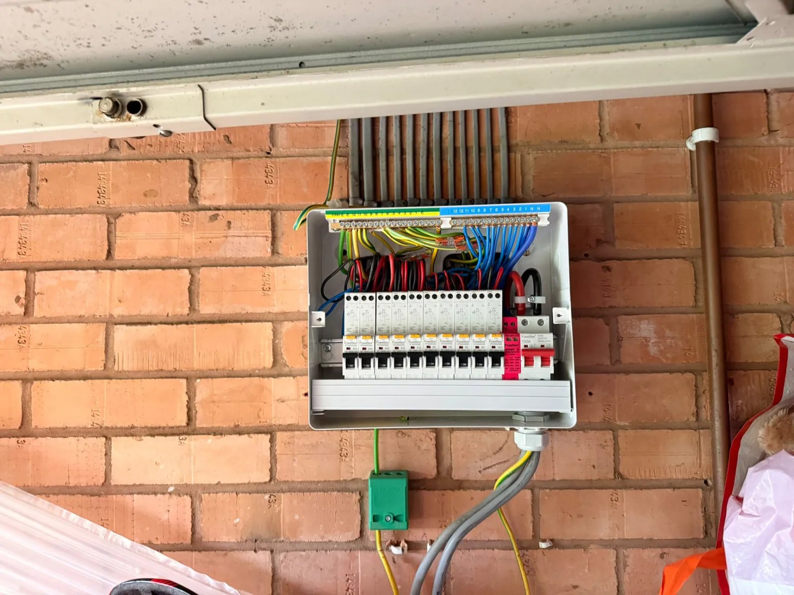 New consumer unit wired on brickwork during installation