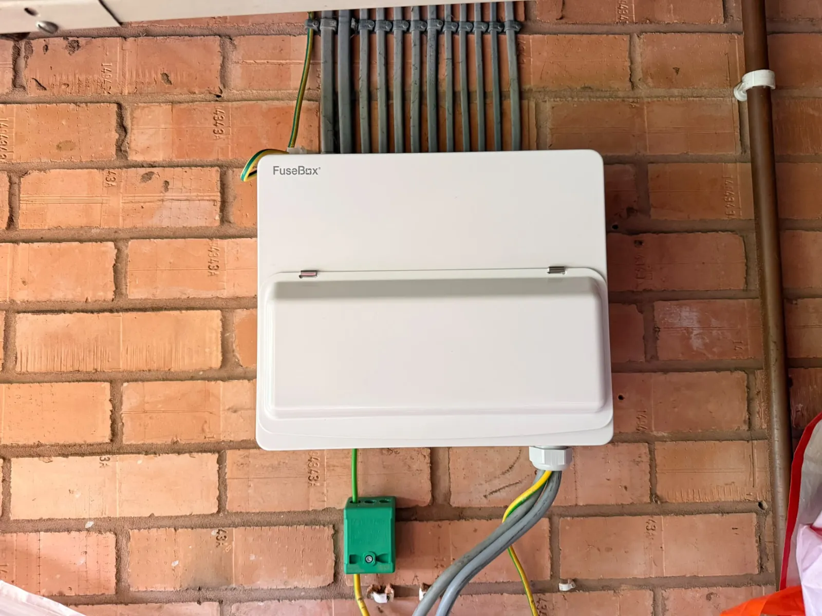 Consumer unit mounted on brickwork with conduit