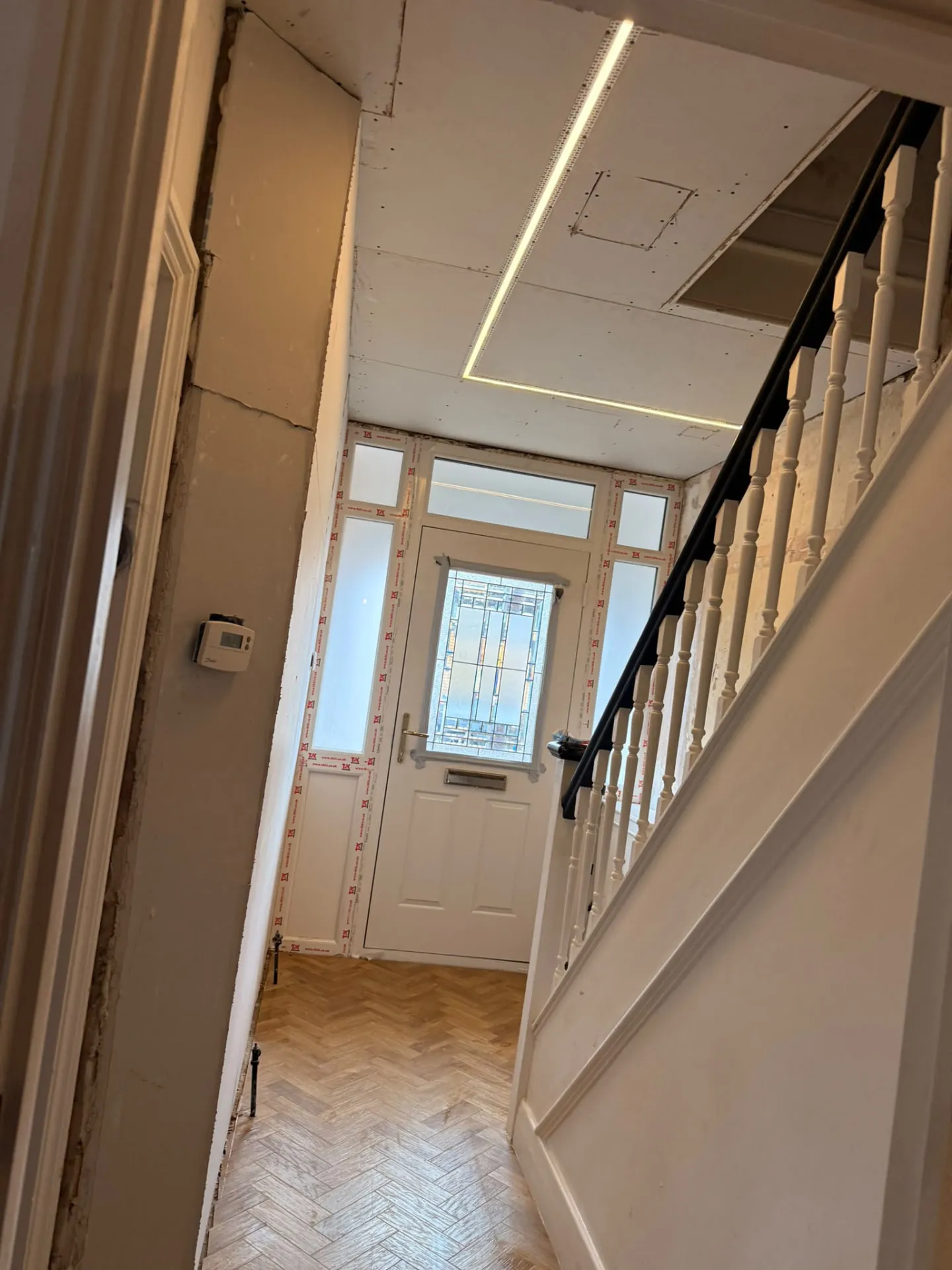 Linear LED lighting being fitted into a hallway ceiling
